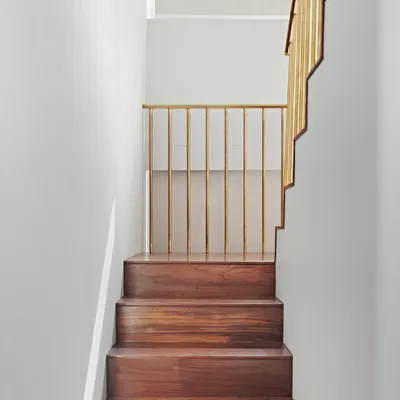 The staircase in the Maximum City Duplex is a sculptural element crafted from teak and brass. We integrated hidden storage into its design, perfectly blending beauty with smart, functional planning.