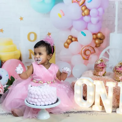 Nothing beats the pure delight of a cake smash. This little one is having the best time with her first birthday cake in our sweet candyland-themed studio setup.