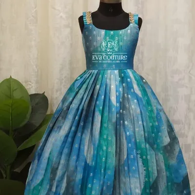 A beautiful sleeveless gown in shades of blue and green. The pleated skirt gives it a lovely flare, and the gold lace straps add a touch of sparkle.