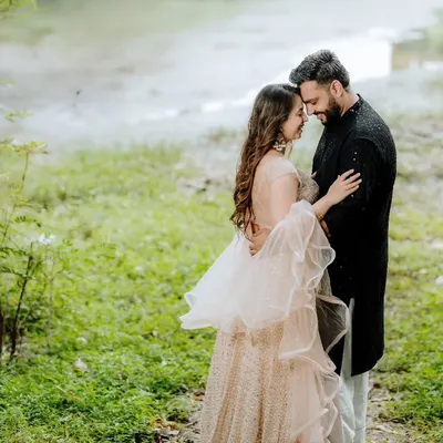 A tender moment between a couple in a lush green, natural setting. This intimate portrait focuses on their quiet connection, with the soft, diffused light adding to the romantic mood.