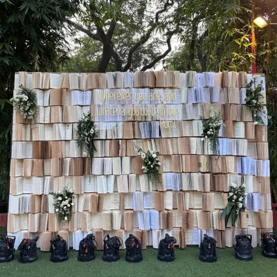 A unique and literary photo backdrop created from hundreds of open books, with a beautiful Rumi quote in gold. This is perfect for couples who are book lovers.