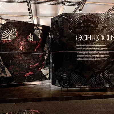 Our design interpretation of 'Gothilicious' for ColourNext23, a contemporary take on Goth culture. The space uses large, curved panels with woven tattoo-style art to project a bold, sensual, and glamorous persona, exploring darker colors and edgy, scarred surface textures.