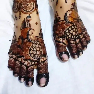 A stunning bridal foot design featuring intricate peacock motifs, a symbol of royalty and grace.