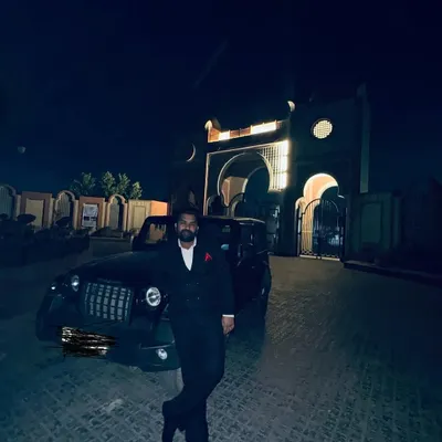 A contemplative moment at night, with my car parked before a grand, arched building. In such moments, I am reminded of Faiz's words that though the night of sorrow is long, it is, after all, just a night.