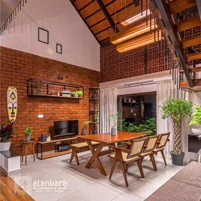 This dining space combines rustic and modern elements, featuring an exposed brick wall and a high, tiled roof. I crafted the solid wood dining table and matching cane-back chairs to create a warm, communal atmosphere.