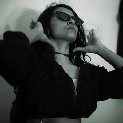 Channeling my 'black cat energy' with sharp sunglasses and a confident pose. This moody, low-key lighting shot is perfect for creating an urban chic aesthetic.