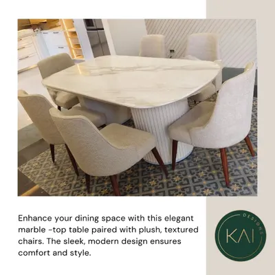 This elegant dining set features a modern marble-top table with an organically shaped surface and a fluted base. The accompanying plush, textured chairs ensure every meal is enjoyed in comfort and style.