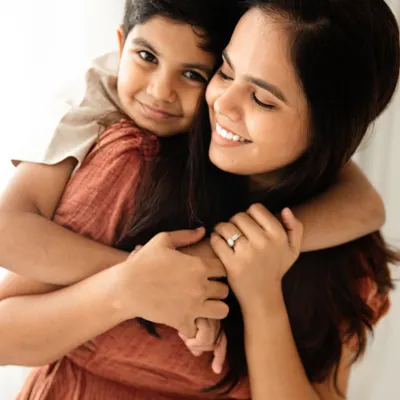 A warm, loving hug from behind. This portrait of a mother and her son is filled with a sense of comfort, safety, and unconditional love.