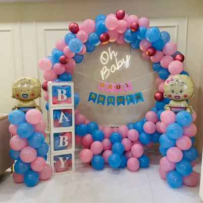 This is a popular gender-neutral baby shower design featuring a full circle balloon arch with both pink and blue balloons. The setup is completed with an "Oh Baby" neon sign, a "Baby Shower" banner, and transparent "BABY" boxes.