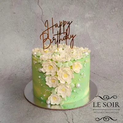 I was so happy with how the buttercream flowers turned out on this cake. This half-kg Biscoff cake features a cascade of hand-piped white and green flowers against a soft green background.