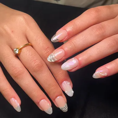 A beautiful bridal set featuring a mix of styles. Some nails have delicate silver line work, while others have a pearlescent chrome finish and tiny pearl accents.