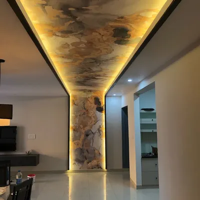 This project shows a custom abstract wallpaper on the ceiling and a connecting pillar, framed with black trim and backlighting. This creates an ultra-modern and luxurious feel in the hallway.