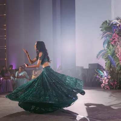 A vision in emerald green. The bride, Nisha, twirls on the dance floor during her Sangeet, her sequined Falguni Shane Peacock lehenga catching the light perfectly. This outfit was made for movement.