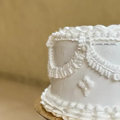 A close-up of the intricate piping on one of our white vintage cakes. The delicate ruffles and swags are piped by hand to create a classic, elegant look.