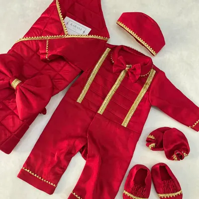 A complete newborn Jamna set in royal red velvet with gold trim. This welcoming outfit includes a romper with a bow tie, a quilted blanket, a cap, and matching booties.