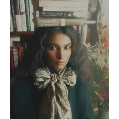 A key image from my 'Roots' editorial. The styling choice of balancing books on the model's head is a direct metaphor for carrying one's history and culture. The oversized bow adds a touch of soft, stylistic contrast.