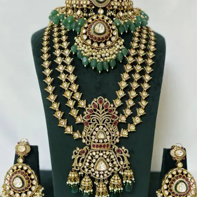 A complete bridal set for rent, featuring a Kundan choker, a matching layered Rani Haar, and oversized earrings. The intricate design with green beads is perfect for a traditional wedding.