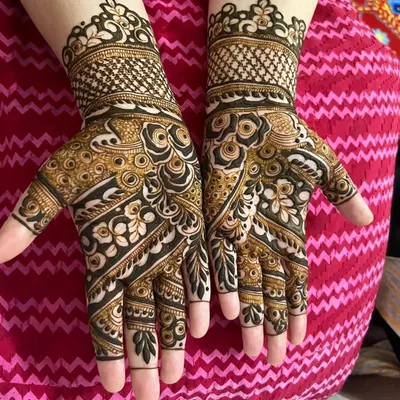 This bold Arabic mehndi design is a favorite for parties and sangeets. The contrast between the thick, dark lines and the delicate shaded floral patterns creates a very striking and modern effect on the hands.