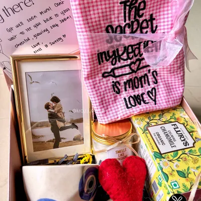 A thoughtful 'Get Well Soon' hamper for a mom, filled with comforting items like chamomile tea, an evil eye mug for good vibes, and a personalized photo frame.