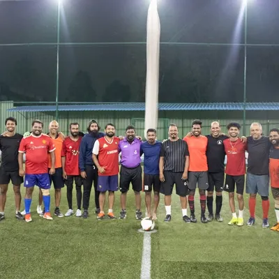 A group photo of adult players from different corporate teams before their match begins on our turf.