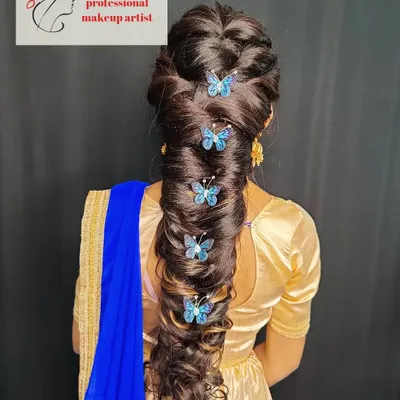 I love getting creative with hairstyles. This is an intricate pull-through braid, decorated with delicate butterfly clips for a touch of whimsy, ideal for a sangeet or special event.