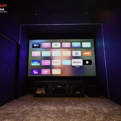 A 7.1.2 home cinema in Madurai, showcasing a clean, minimalist design in a compact space. The deep blue walls and integrated lighting create a modern and immersive feel.