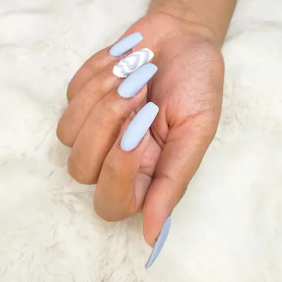 A single hand showing off the trendy sky blue manicure with a detailed, multi-layered white heart on the accent nail.