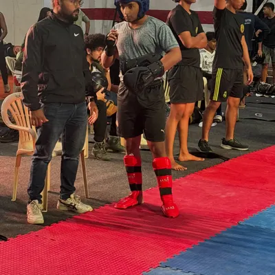 Getting ready to step into the ring for a kickboxing bout. I stand by my fighters, making sure they are mentally and physically prepared with the right gear and the right strategy.