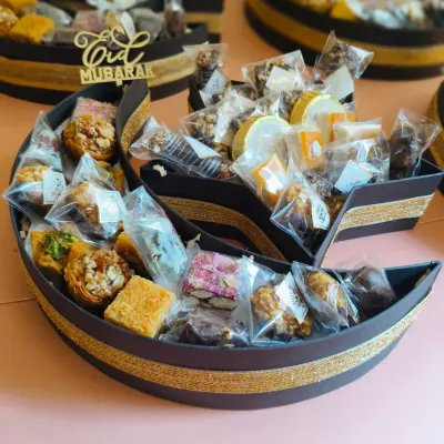My 'Chand Taara' Eid gourmet hampers were a big hit this season. This crescent-shaped platter is overflowing with delicious treats like baklava, date and almond bites, and other sweets.