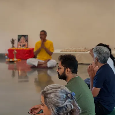 Participants listen with focus during an in person satsang. These sessions are not lectures but shared explorations into topics that matter, guided by the principles of Sivananda philosophy.