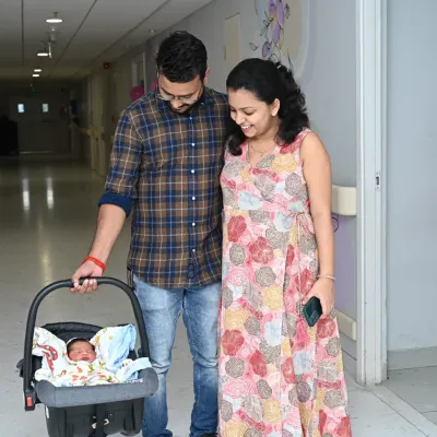 The first family photo. New parents gaze lovingly at their newborn in a car seat, just moments before taking him home from the hospital. These are the priceless memories I help capture.
