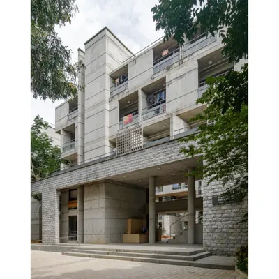 The entrance to the new hostel block at IIM Bangalore, showing how the G+4 structure is scaled down with a recessed upper floor and a stone-clad base to feel less intimidating and blend with the campus.