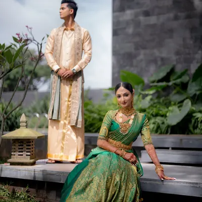 A beautifully composed portrait of the bride and groom. Her radiant green saree look and his classic cream outfit create a perfect picture of elegance.