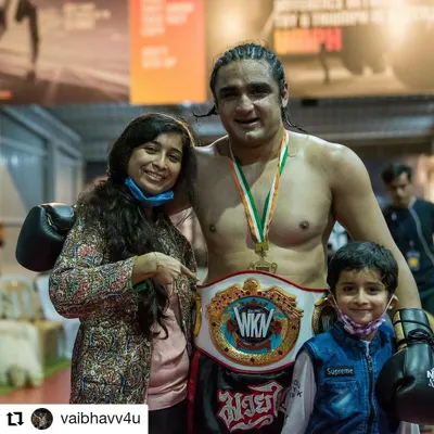 Celebrating a victory is always sweeter with your friends, family, and teammates around. Here's a student with his championship belt after a kickboxing competition.
