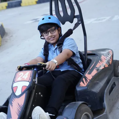 A happy racer is buckled in and ready to hit the track. Our karts are designed for kids, ensuring a safe and exciting go-karting experience.