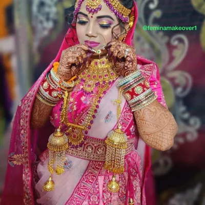 A quintessential North Indian bride in a stunning pink lehenga. The look features classic gold and pink cut-crease eyeshadow, a flawless base, and traditional jewellery with `kalire`.
