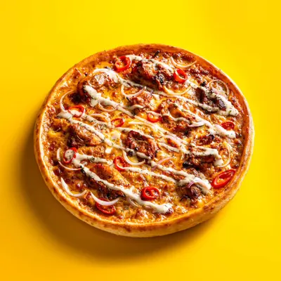 A chicken tikka pizza shot on a bright yellow background. This high-contrast, minimalist style is proven to perform well on food delivery apps.