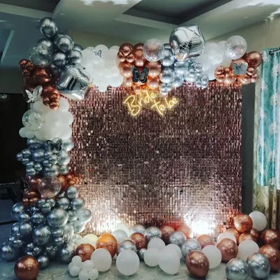 I create stunning photo backdrops like this rose gold shimmer wall for a bridal shower. The setup includes a custom 'Bride to Be' neon sign and an elaborate balloon arch with chrome, white, and metallic balloons.