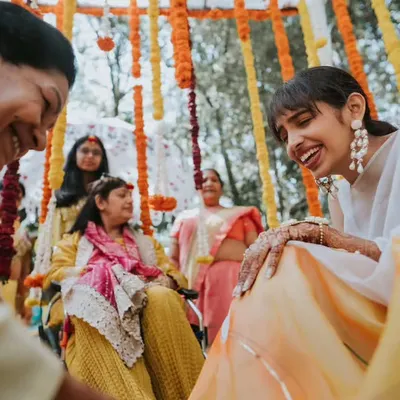A beautiful, candid moment of laughter between the bride and her family during the Haldi ceremony. These are the memories we love to create the backdrop for.