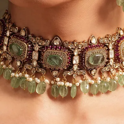 A detailed close-up of a choker with rectangular emeralds and polki diamonds, showing the intricate setting and craftsmanship.