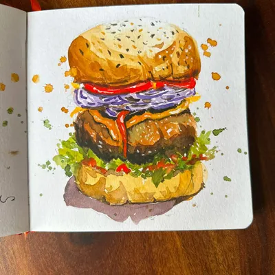 A detailed watercolor illustration of a delicious burger from my sketchbook. I focused on capturing the layers, from the toasted sesame seed bun to the fresh toppings, making it look as tasty on paper as it is in real life.