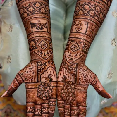 This full bridal mehendi is a masterpiece of symmetry and detail. It features majestic peacocks, auspicious symbols, and geometric patterns, creating a rich and traditional look for the bride.