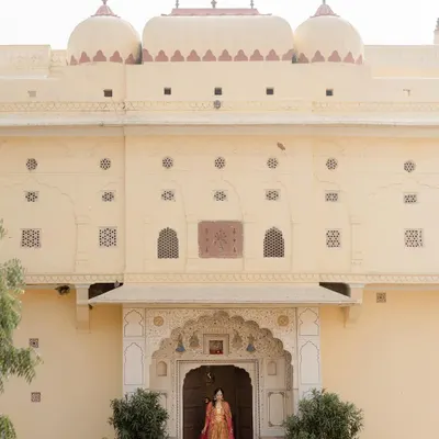 A bride stands in the doorway of a Jaipur palace. I use the grandeur of destination venues to create portraits that feel both personal and epic in scale.