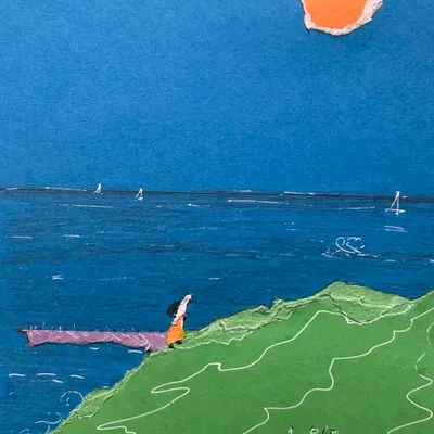 A serene seascape created with torn paper collage. The different shades of blue paper form the ocean, while a simple figure looks out from a green hill, showing how simple shapes can create a powerful scene.