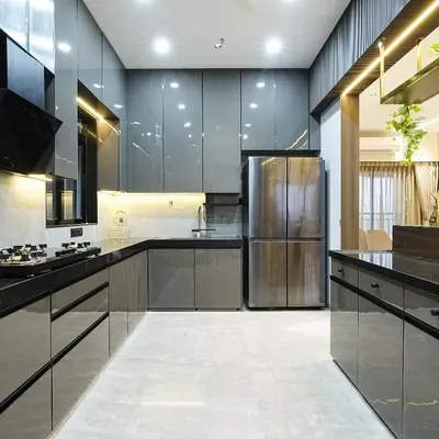 This open kitchen concept with a high-rise island counter embodies sleek modernism and understated opulence. The charcoal grey tone seamlessly blends with the kitchen's glossy black cabinetry, creating a cohesive, monochromatic palette that invites both culinary creativity and social interaction.