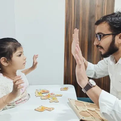 A high-five after a successful puzzle activity is more than just a celebration. It's a key moment in our language therapy sessions, building confidence and reinforcing positive learning behaviors in a one-on-one setting.