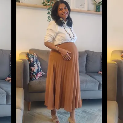 A classic white shirt paired with a flowing pleated skirt is a perfect example of a non-maternity item that beautifully accommodates a growing bump. This look is comfortable enough for daytime and elegant enough for an evening out.