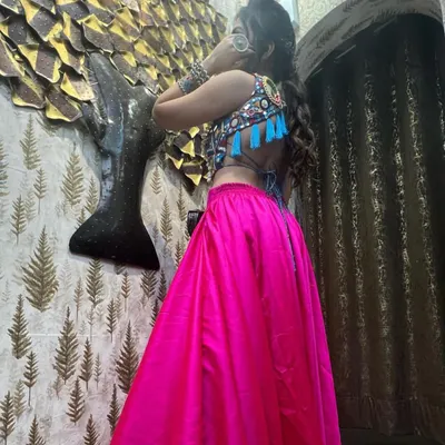 The back of my Navratri outfit, featuring a stunning mirror-work blouse and a bright pink skirt. The backless design with tassels adds a playful and modern touch to this traditional garba look.