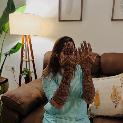 A happy client playfully showing off her full-arm traditional mehndi. The joy and confidence that a beautiful design brings is what I aim for.