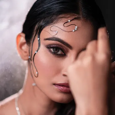 An artistic beauty shot featuring a wet-hair look with pearl embellishments. The dark background and focused lighting create a high-fashion, editorial feel, perfect for a creative portfolio.